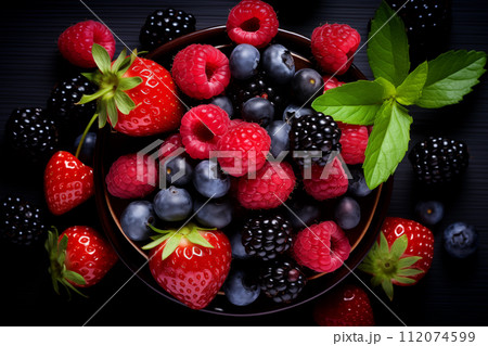 Healthy mix berries fruits clean eating selection in wooden bowl on black background. Cherry, blueberry, raspberry colorful fruits organic food top view flat lay 112074599