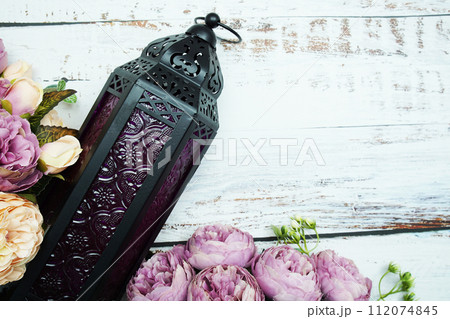 Black Moroccan Arabic lantern with flower on white table background 112074845