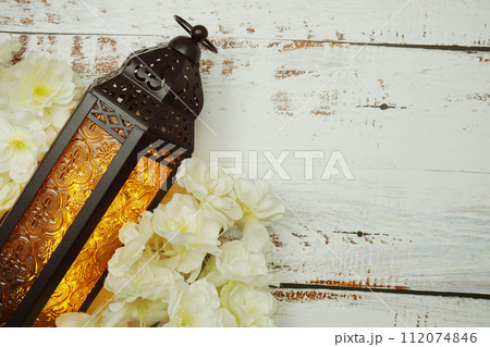 Black Moroccan Arabic lantern with flower on white table background 112074846
