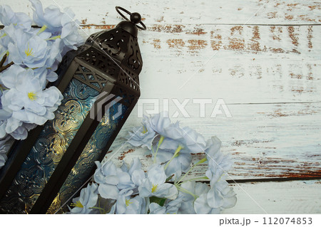 Black Moroccan Arabic lantern with flower on white table background 112074853