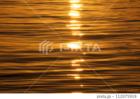 今治鴨池海岸での夕日に照らされた波紋 112075919