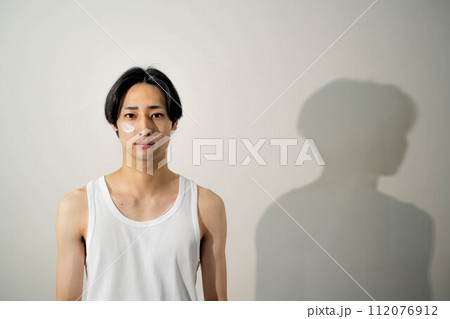 白いバックでポージングをする若いタンクトップの男性 白いバックでポージングをする若いタンクトップの男性 112076912