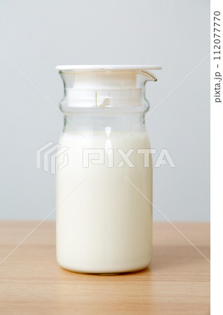 ガラスのミルクポットに入った牛乳 112077770