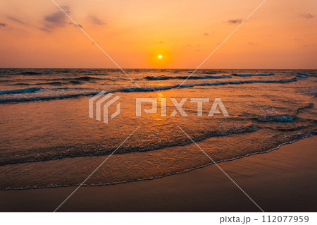 Sunset on the beach and orange sea waves 112077959
