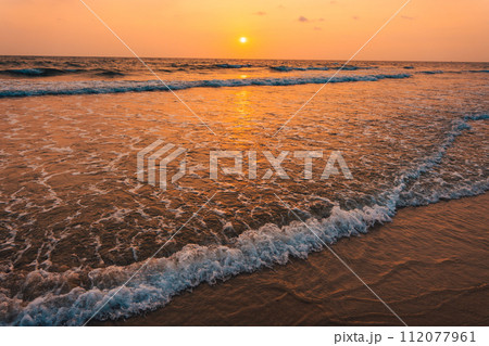 Sunset on the beach and orange sea waves Sunset on the beach and orange sea waves 112077961