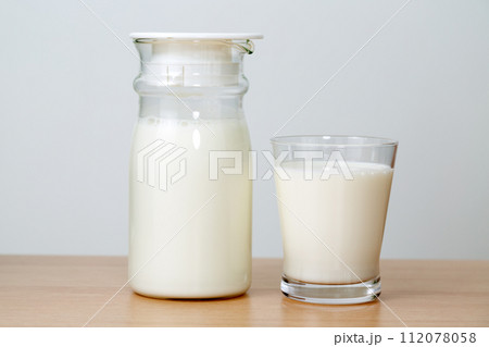ガラスのミルクポットとグラスに入った牛乳 ガラスのミルクポットとグラスに入った牛乳 112078058