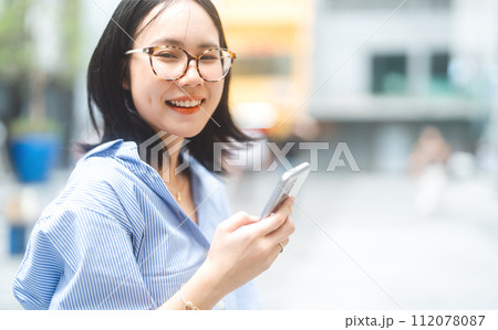 Business asian woman using smartphone city lifestyles with casual fashion positive look Business asian woman using smartphone city lifestyles with casual fashion positive look 112078087