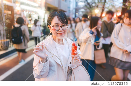 Asian woman eating popular menu in sakura festival Nakameguro Tokyo city at night street travel 112078356