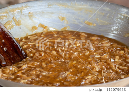 thin coconut flakes fried in sugar syrup thin coconut flakes fried in sugar syrup 112079638