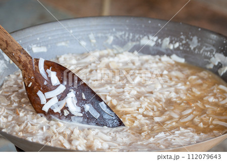 thin coconut flakes fried in sugar syrup 112079643