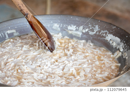thin coconut flakes fried in sugar syrup 112079645