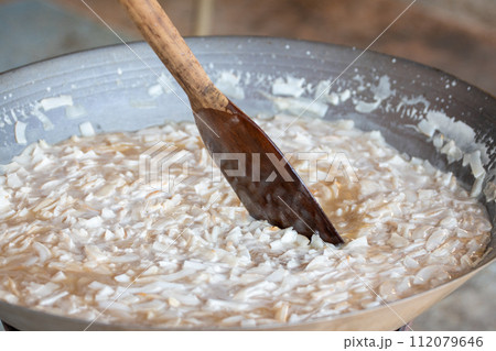 thin coconut flakes fried in sugar syrup 112079646