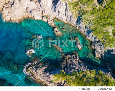 青い海と緑の森が美しい、式根島の泊海水浴場の空中ドローン撮影。 東京都伊豆諸島新島村式根島にて。 青い海と緑の森が美しい、式根島の泊海水浴場の空中ドローン撮影。 東京都伊豆諸島新島村式根島にて。 112080248