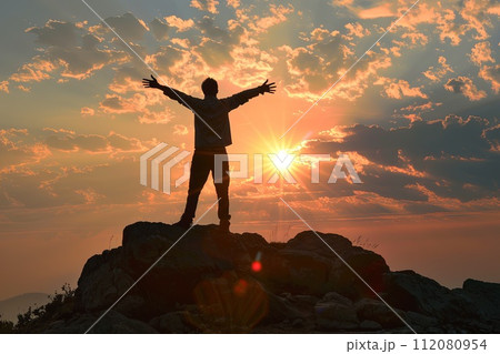 Man Standing on Top of a Mountain With Arms Outstretched Man Standing on Top of a Mountain With Arms Outstretched 112080954