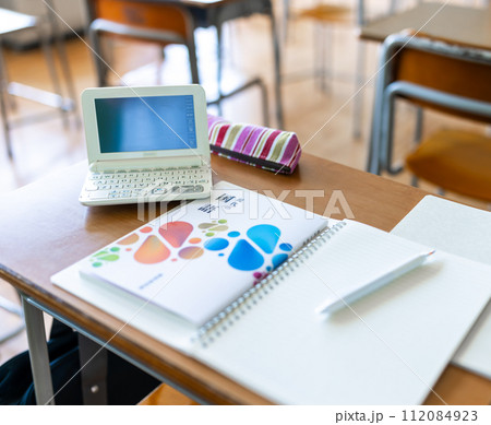 教室の机に置かれた教科書やノート 112084923