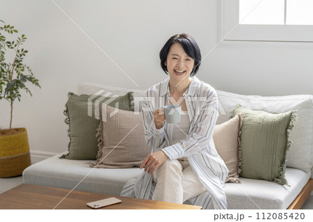 マグカップを持った笑顔の50代前半の女性 マグカップを持った笑顔の50代前半の女性 112085420
