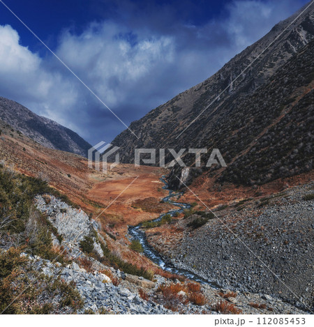 beautiful panorama landscape with river stream in an autumn orange valley in the mountains in fall 112085453