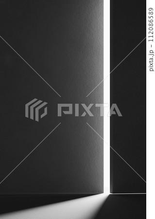 A black and white background with light coming through the building structure. 112086589