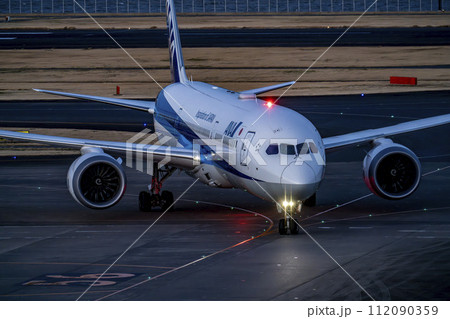 夕暮れの羽田空港　タキシング中の飛行機　東京都大田区 112090359