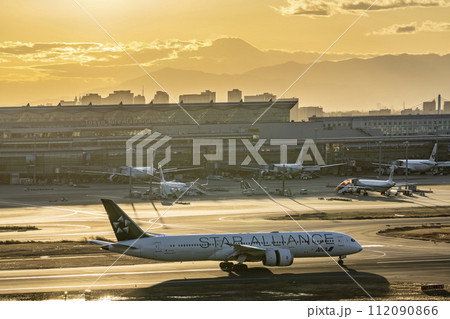 夕暮れの羽田空港　着陸した飛行機と富士山　東京都大田区 112090866
