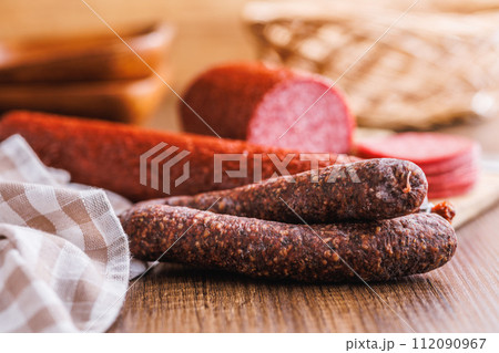 Smoked salami sausages on wooden table. Smoked salami sausages on wooden table. 112090967