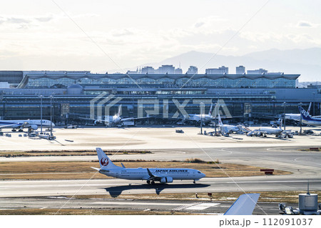 夕暮れの羽田空港　タキシング中の飛行機と第3ターミナル　東京都大田区 112091037