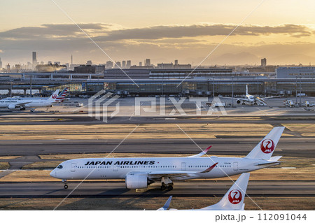 夕暮れの羽田空港 タキシング中の飛行機と第3ターミナル 東京都大田区 夕暮れの羽田空港 タキシング中の飛行機と第3ターミナル 東京都大田区 112091044