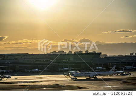 夕暮れの羽田空港　トーイングカーと飛行機　東京都大田区 112091223