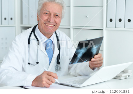 Portrait of senior male doctor with x-ray 112091881