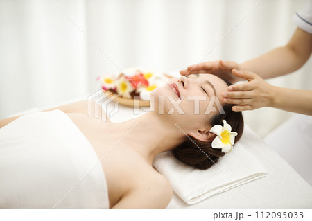 エステティシャンにマッサージを受ける女性 112095033