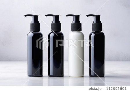 Black and white bottles for cosmetics and personal skin care products are arranged in a row. Empty label template mock up. Blank packaging on a marble white background. Front view. Containers set 112095601