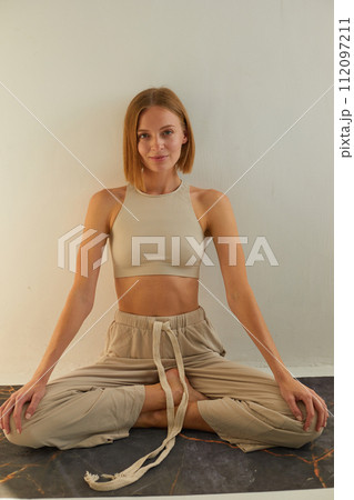 Woman practicing yoga and meditation in lotus pose on yoga mat, relaxed. Mindful meditation concept. Wellbeing Woman practicing yoga and meditation in lotus pose on yoga mat, relaxed. Mindful meditation concept. Wellbeing 112097211
