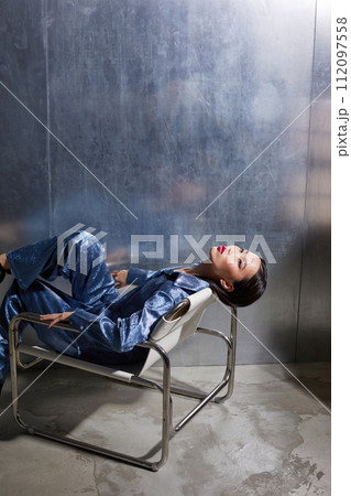 Fashion asian female model in blue glitter suit posing on metallic modern futuristic location. Fashion asian female model in blue glitter suit posing on metallic modern futuristic location. 112097558