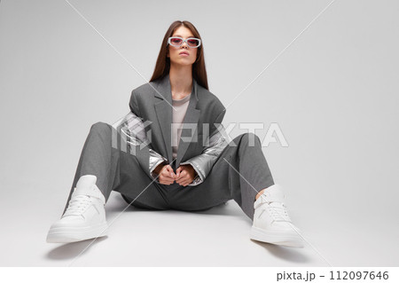 Fashion asian female model in silver down jacket and grey suit. 112097646