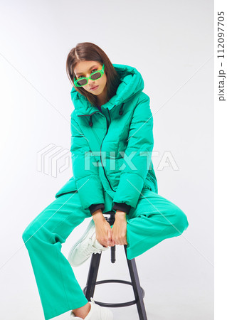 Fashion asian female model in green down jacket and pants. Fashion asian female model in green down jacket and pants. 112097705