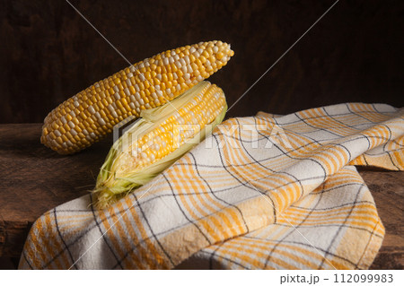 Two cobs sweet corn on wooden background.. 112099983