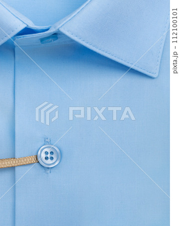 Close-up of a button placket on a light blue men's shirt Close-up of a button placket on a light blue men's shirt 112100101
