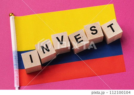 Wooden cubes with text and a flag on a colored background, a concept on the topic of investment in Colombia 112100104