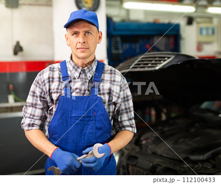Professional auto mechanic posing in workshop Professional auto mechanic posing in workshop 112100433