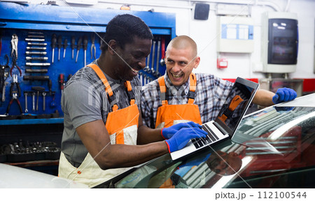 Two masters are replacing the filter in car on workplace 112100544