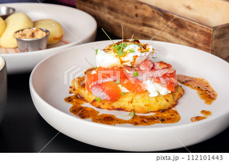 Potato pancake with salmon and poached egg, close up photo Potato pancake with salmon and poached egg, close up photo 112101443