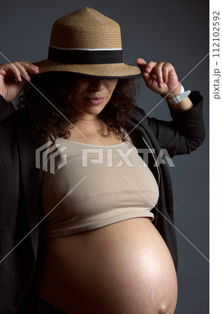 Charming sexy pregnant woman with naked belly, in last trimester of pregnancy, isolated fashion gray studio background. Charming sexy pregnant woman with naked belly, in last trimester of pregnancy, isolated fashion gray studio background. 112102592