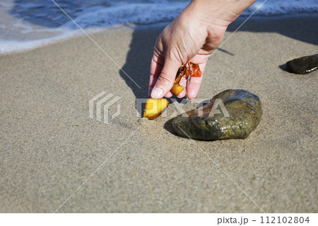 Beautiful pieces of amber in the hand of the sea background. A glowing wavy piece of amber in the palm of your hand. The sunstone. Beautiful pieces of amber in the hand of the sea background. A glowing wavy piece of amber in the palm of your hand. The sunstone. 112102804