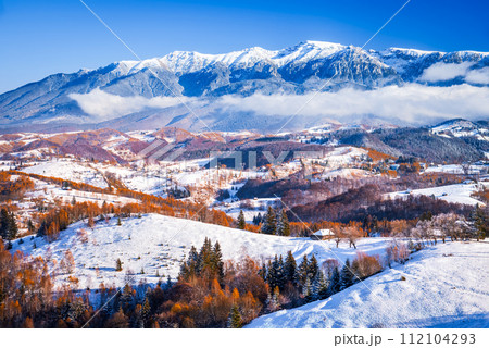 Carpathian Mountains, Romania. Winter snowy landscape with Sirnea village and Bucegi Mountains. 112104293