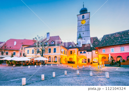Sibiu, Romania. Morning dusk with Council Tower in Lesser Square. Medieval city in Transylvania. Sibiu, Romania. Morning dusk with Council Tower in Lesser Square. Medieval city in Transylvania. 112104324