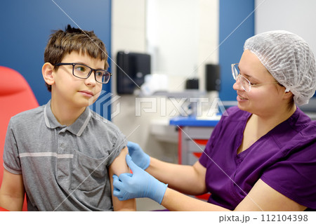 A little boy is being vaccinated. A child is very afraid of the injection. Schoolkid nervous during scheduled vaccination. Close up A little boy is being vaccinated. A child is very afraid of the injection. Schoolkid nervous during scheduled vaccination. Close up 112104398