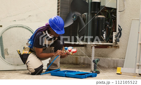 Knowleadgeable engineer unpacking toolkit with professional manometer equipment needed to check freon levels. Certified technician preparing for annual HVAC system maintenance Knowleadgeable engineer unpacking toolkit with professional manometer equipment needed to check freon levels. Certified technician preparing for annual HVAC system maintenance 112105522