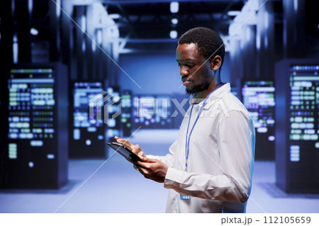 Expert preparing server farm recovery plan monitoring data center energy consumption across components, making sure sensors are functioning optimally, doing routine disk checks Expert preparing server farm recovery plan monitoring data center energy consumption across components, making sure sensors are functioning optimally, doing routine disk checks 112105659