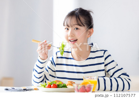ファミリーイメージ　朝食を食べる女の子 112107577
