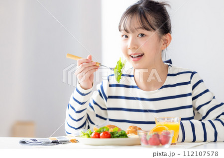 ファミリーイメージ　朝食を食べる女の子 112107578